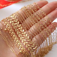 a woman's hand with gold bracelets and chains