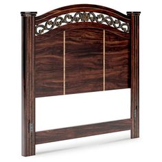 a wooden headboard with intricate carvings on the top, and sides in dark wood