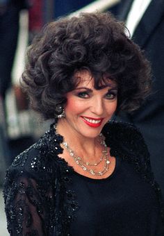 an older woman with dark hair wearing a black dress