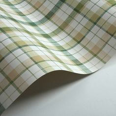 a green and white checkered fabric is laying on top of a tablecloth that has been folded over