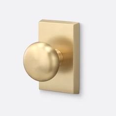 a gold door knob on a white wall with a round ball at the end of it