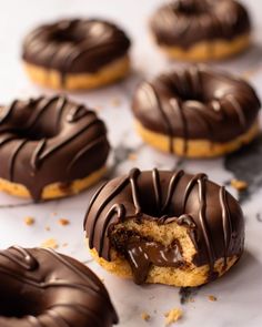 chocolate covered doughnuts with one bite taken out