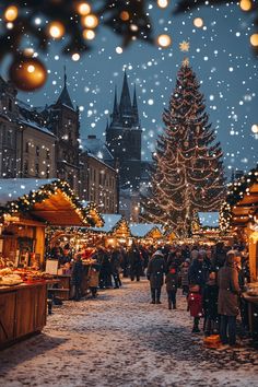 people are walking through an outdoor market with christmas lights on the trees and buildings in the background