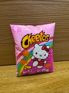 a bag of hello kitty cheetos sitting on top of a wooden table next to a wall