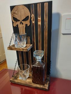 a bottle of whiskey and two glasses on a wooden tray with chains hanging from it