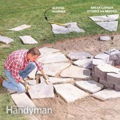 a man is working on some rocks in the yard