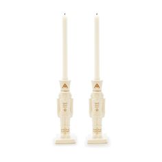 two white candles sitting next to each other