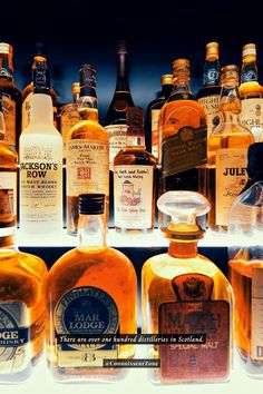 many bottles of liquor are lined up on a shelf