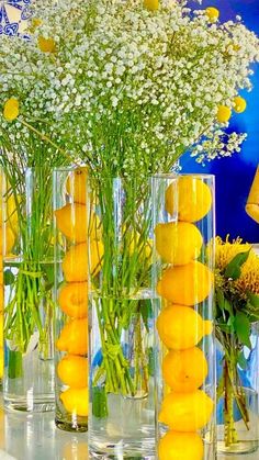 there are many vases with flowers and lemons in them