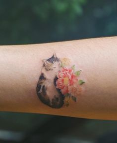 a cat with flowers on it's arm