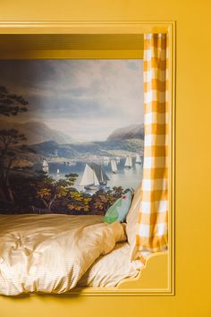 a bedroom with a painting on the wall and a yellow bed frame in front of it