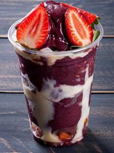 a dessert with strawberries in it on a wooden table