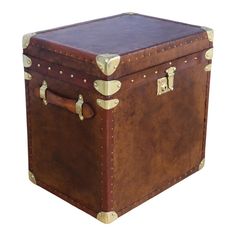 a brown leather trunk with brass hardwares on the top and bottom, sitting against a white background