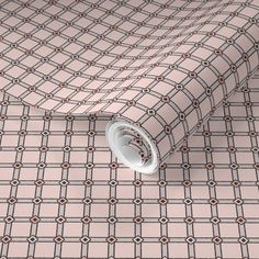 a pink and grey checkered tie laying on top of a white wallpaper covered floor