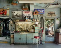 an old garage with various items on the wall and in the ceiling, there are two stools