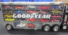 a toy truck with cars and trucks on it's back in a display case