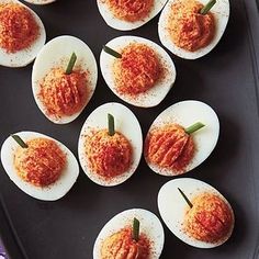 deviled eggs are arranged on a black tray