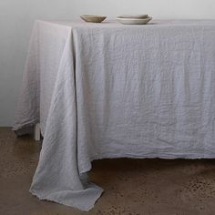 a table with two plates on it and a white cloth draped over the table top