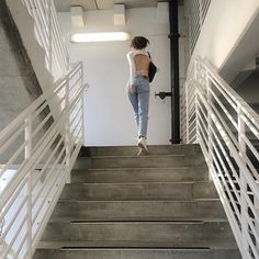 a woman walking up some stairs with her back to the camera