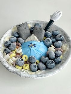 a bowl filled with blueberries, bananas and other foods on top of a table