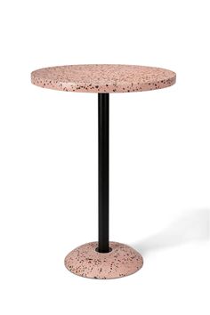 a pink table with black metal legs and a round top on an isolated white background