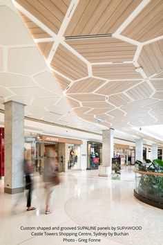 people are walking through the lobby of a shopping mall