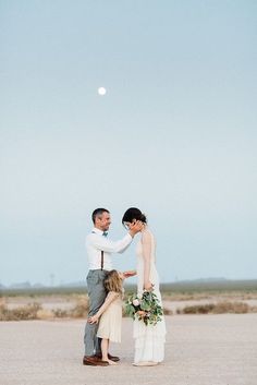 a man and woman standing next to each other in the desert