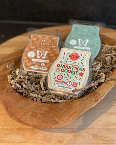 three different types of christmas cookies in a wooden bowl on top of wood shavings