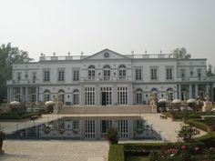 a large white house with a pool in the front yard