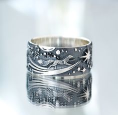 a silver ring with an image of a fox on the moon and stars in the sky