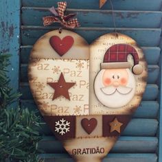 a wooden heart hanging from the side of a building with santa clause on it's face