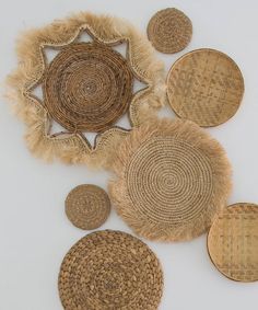 several woven baskets are arranged on a white surface