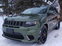 a green jeep is parked in the snow