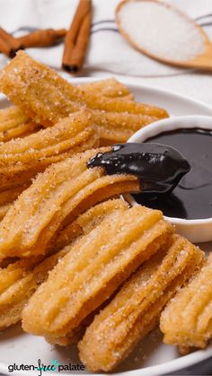 some churros on a plate with dipping sauce