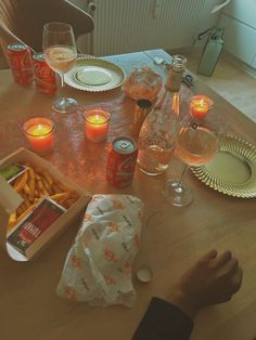 a table topped with lots of food next to wine glasses and plates on top of a wooden table