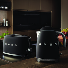 two black toasters sitting on top of a wooden counter