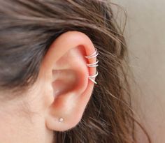 a woman's ear is shown with three small spirals on it