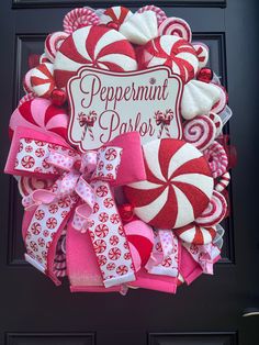 a red and white wreath with candy canes on it that says peppermint parlor