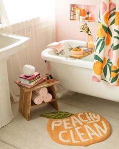 a bath tub sitting next to a white sink in a bathroom with orange shower curtains