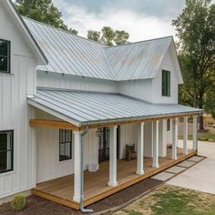 a white house with a metal roof and porch