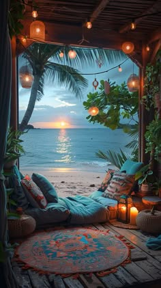 an outdoor area with lights, pillows and rugs on the floor next to the ocean