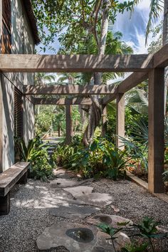 an outdoor area with trees and plants on the ground, surrounded by stone walkways