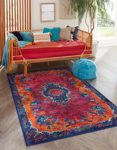 a living room with a red couch and colorful rug