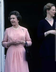 two women standing next to each other in front of a door