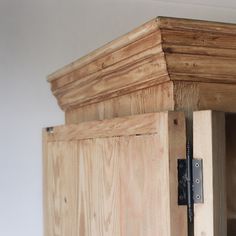 a close up of a wooden cabinet with a metal latch on the front and side