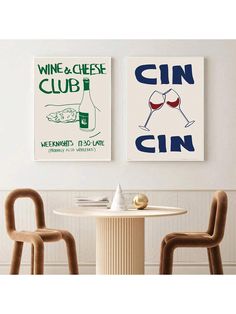 two posters are hanging on the wall above a table with chairs and a wine glass