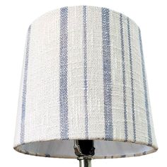 a table lamp with a white and blue striped shade on the bottom half of it