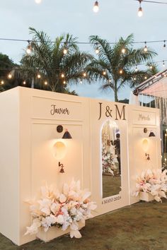 a couple of white booths sitting on top of a grass covered field next to palm trees