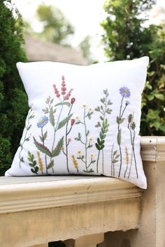 a white pillow sitting on top of a wooden bench