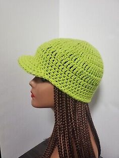 a mannequin head wearing a lime green knitted hat with braids on it